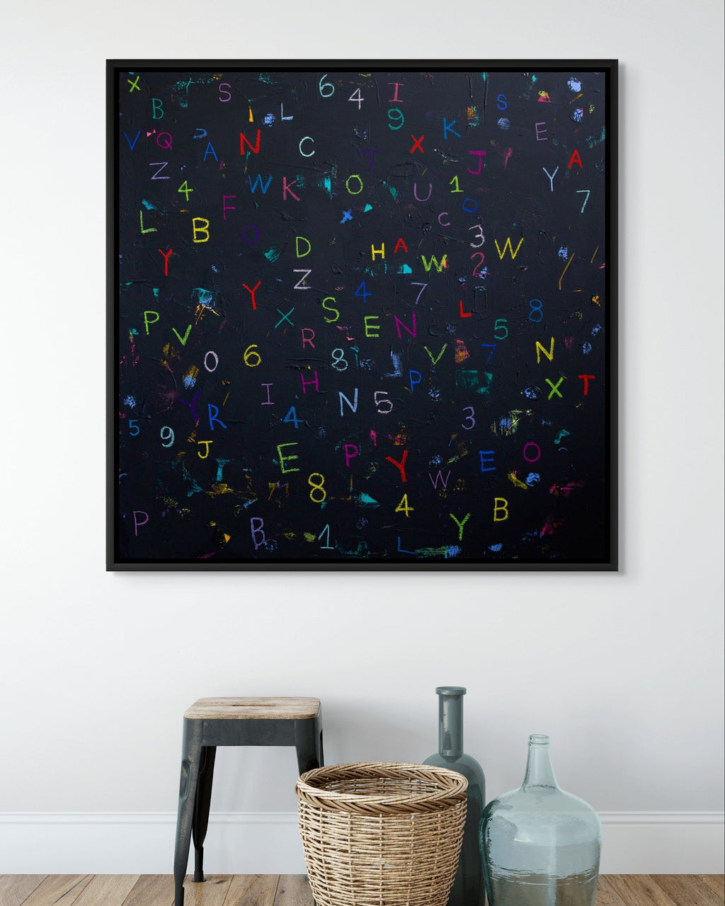 Framed artwork with colorful letters and numbers on a white wall.