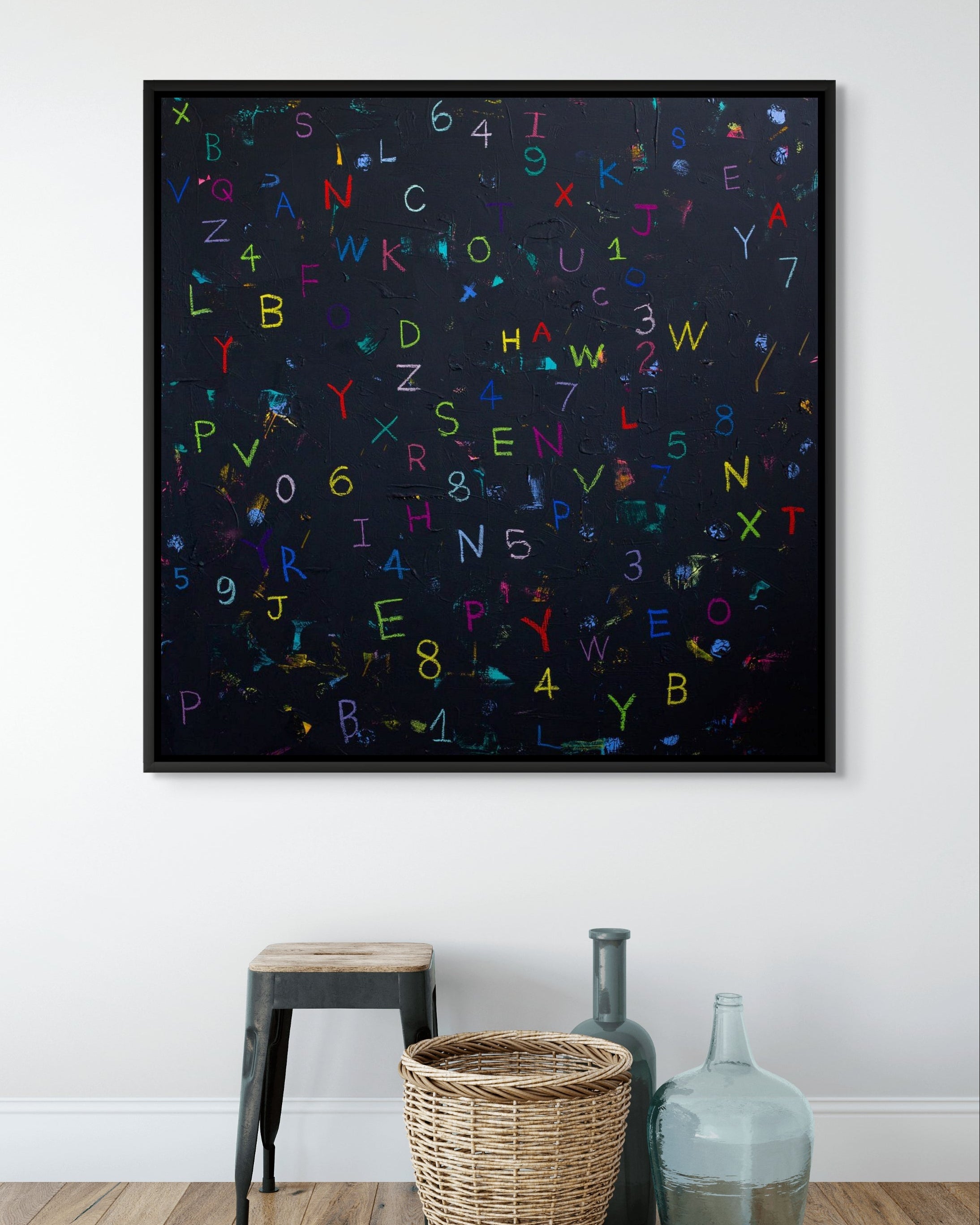 Framed artwork with colorful letters and numbers on a white wall.