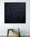 Framed artwork with colorful letters and numbers on a white wall.