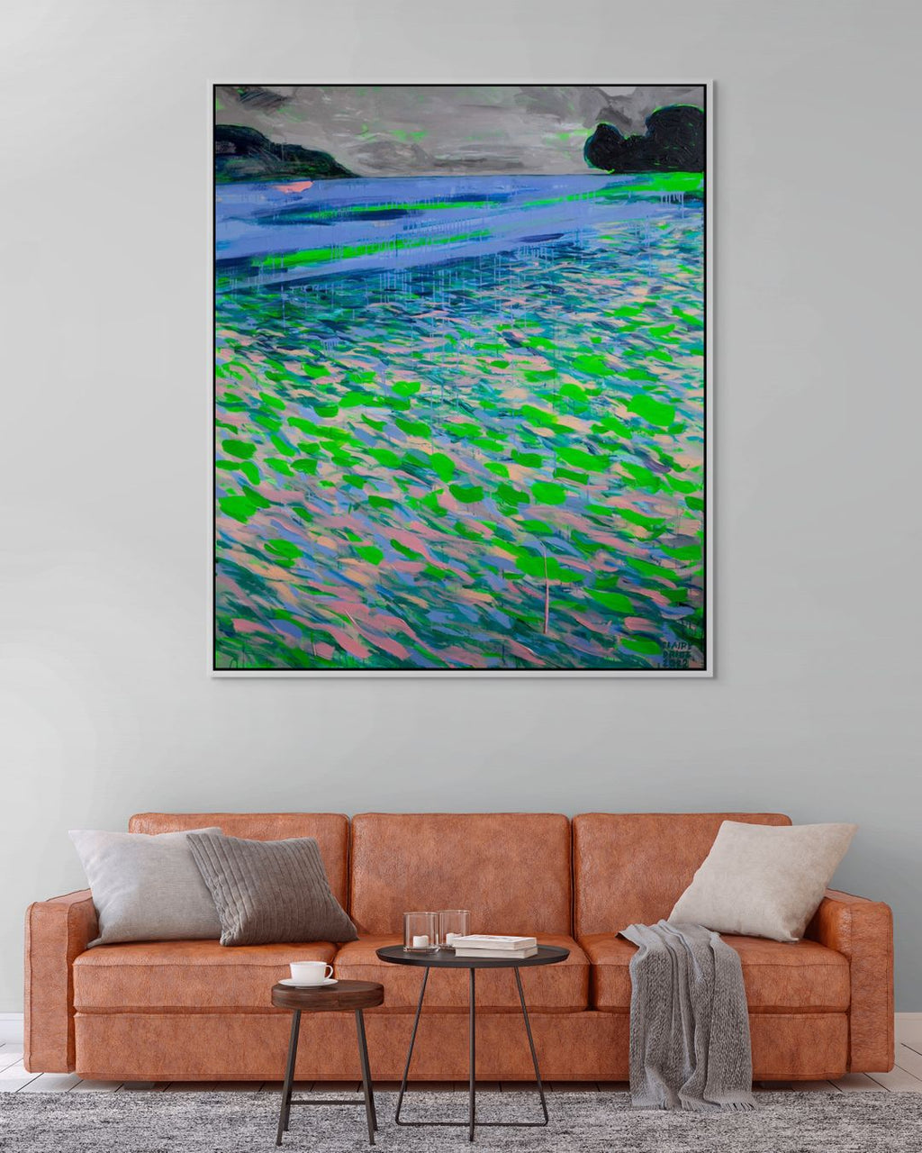 Living room with a brown sofa, small round table, and abstract painting on the wall.